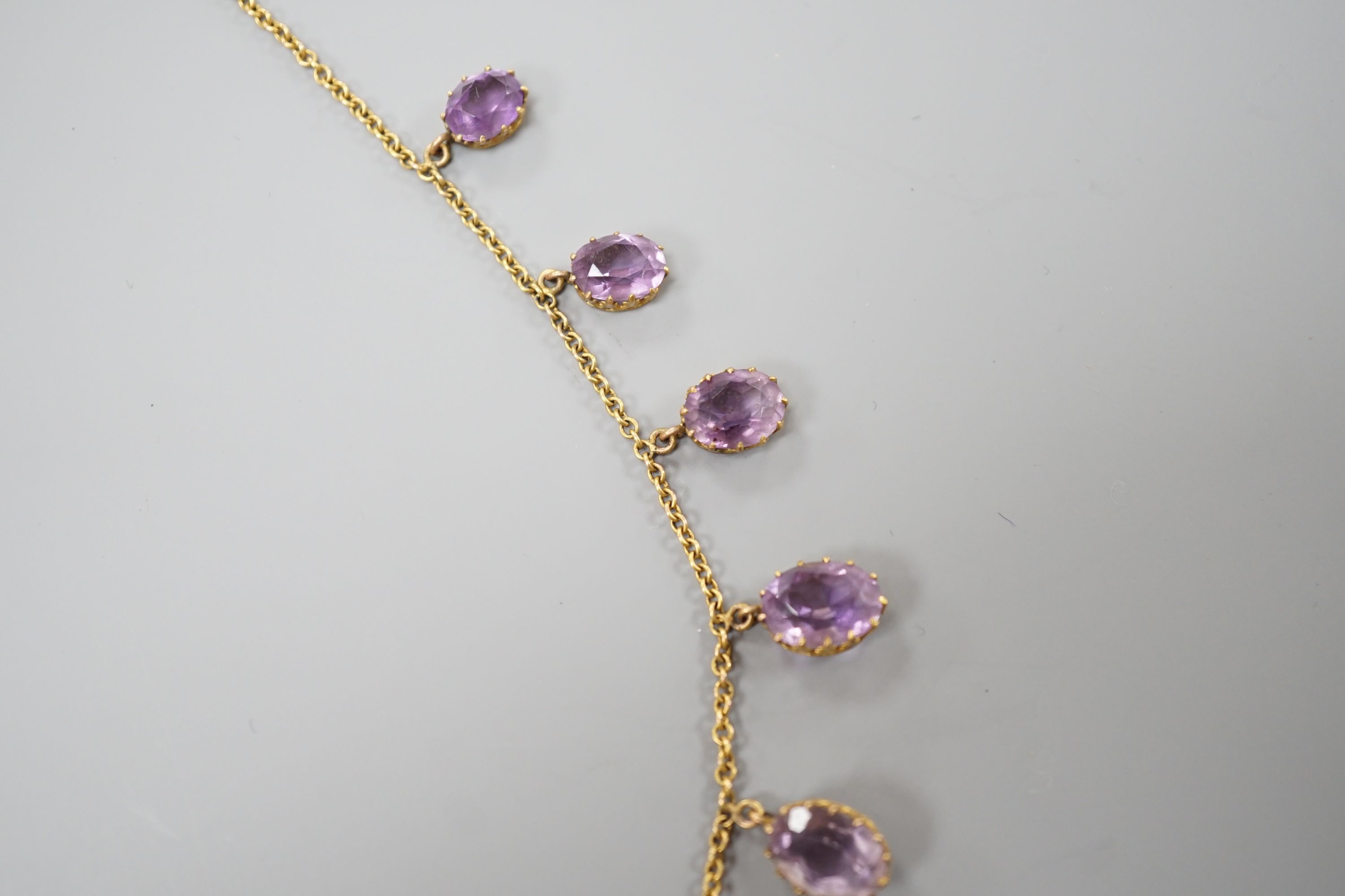 An early 20th century 9ct and graduated oval cut amethyst set drop fringe necklace, 45cm, gross weight 11.8 grams.